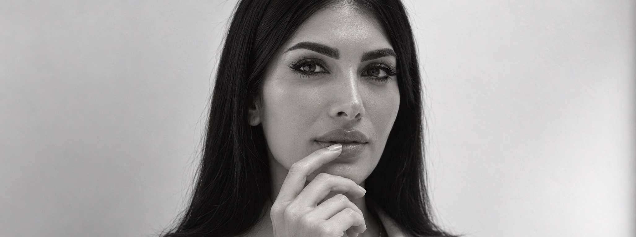 Black and white close-up of Diana, fingertip resting at her lip