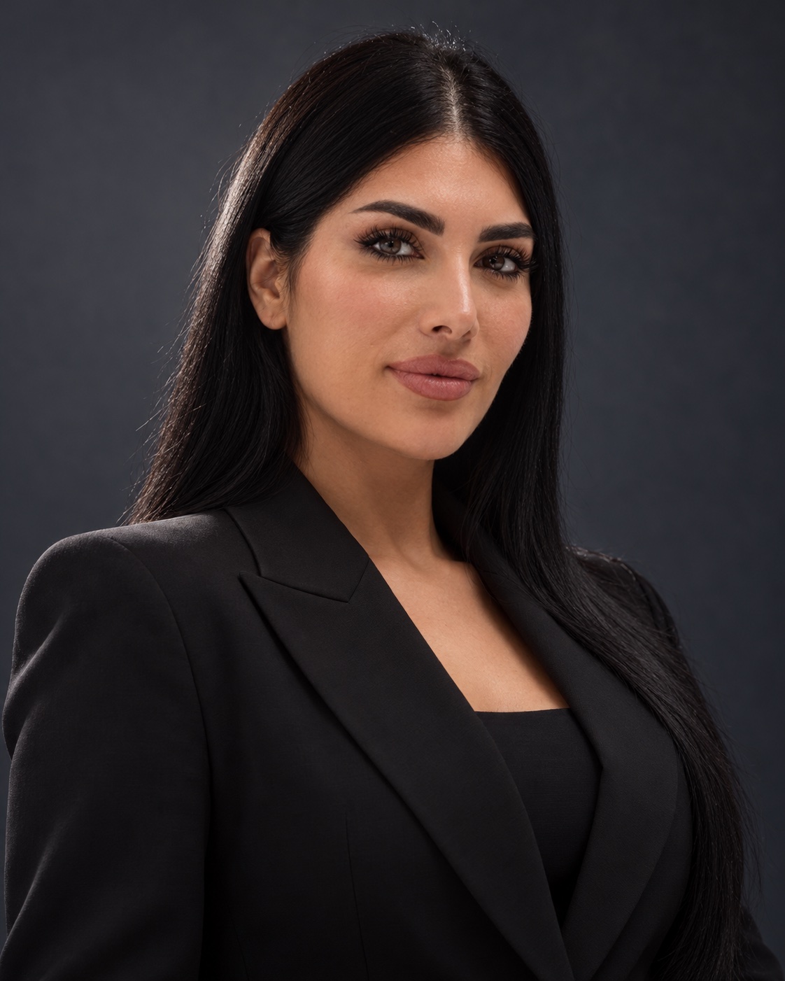 Diana in a black tailored suit against a slate backdrop
